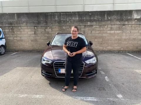 MKAA-Kundin mit ihrem braunen Audi A3 Sportback auf dem Filial-Parkplatz