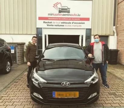 Zwei MKAA-Kunden mit ihrem schwarzen Hyundai i20 vor der Filiale Bertrange